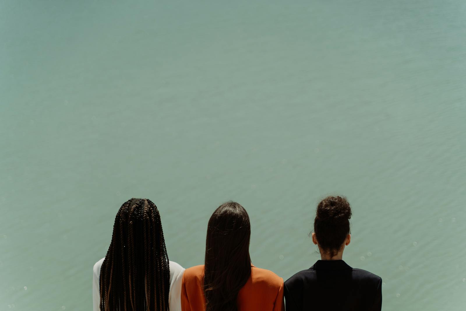 Trois personnes de dos face à un plan d’eau calme, ambiance paisible